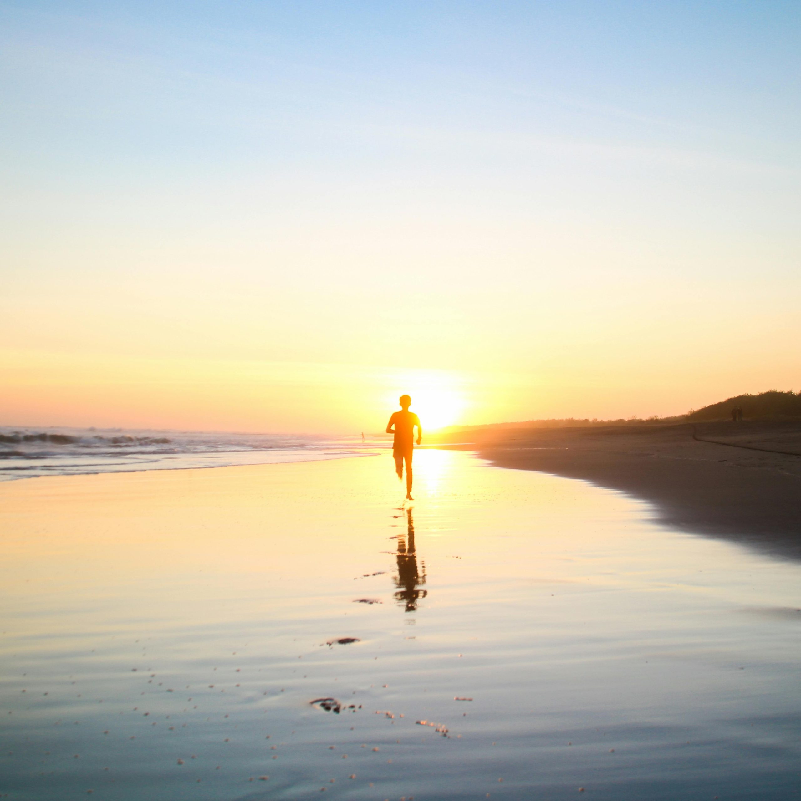 Person running on the edge of the ocean.